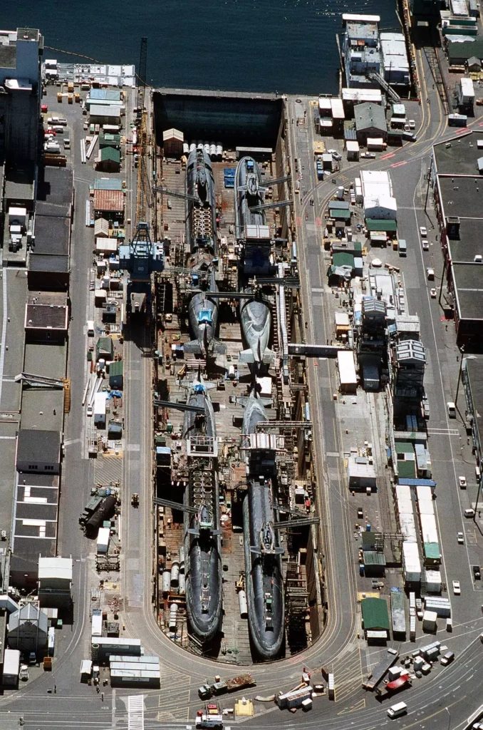 An aerial shot of four LaFayette class nuclear-powered ballistic missile submarines at the beginning of their dismantling process in a dry dock. 