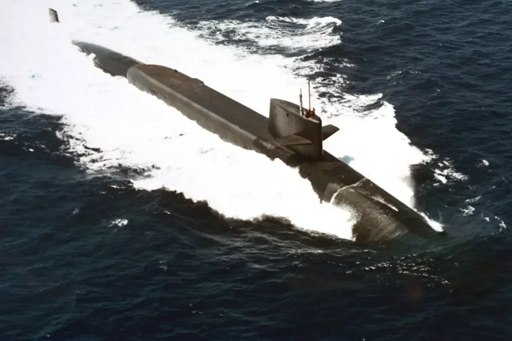 Aerial port bow view of USS Benjamin Franklin (SSBN 640). She was the seventh Poseidon submarine backfitted with Trident I (C4) missiles. 